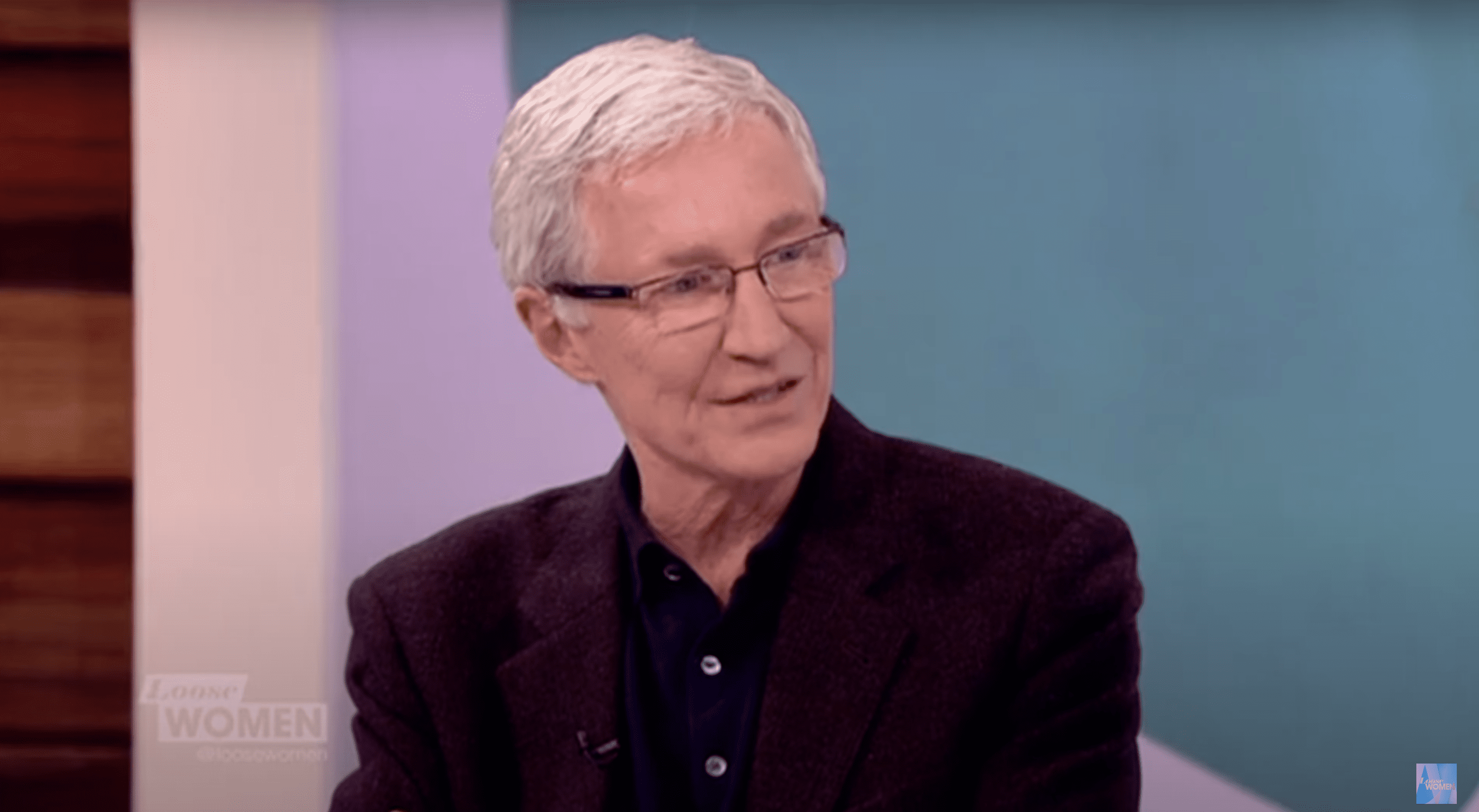 Paul O'Grady chatting about his alter-ego Lily Savage on Loose Women wearing a burgundy suit and glasses