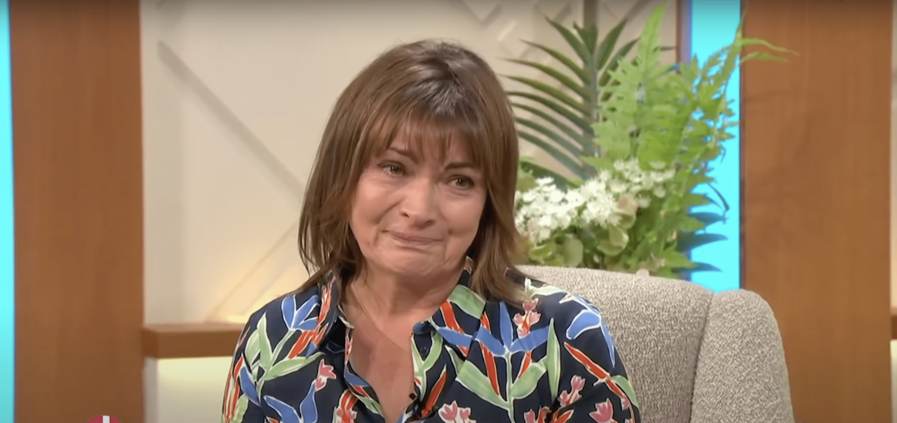 Lorraine Kelly in tears wearing a floral dress on her TV show Lorraine