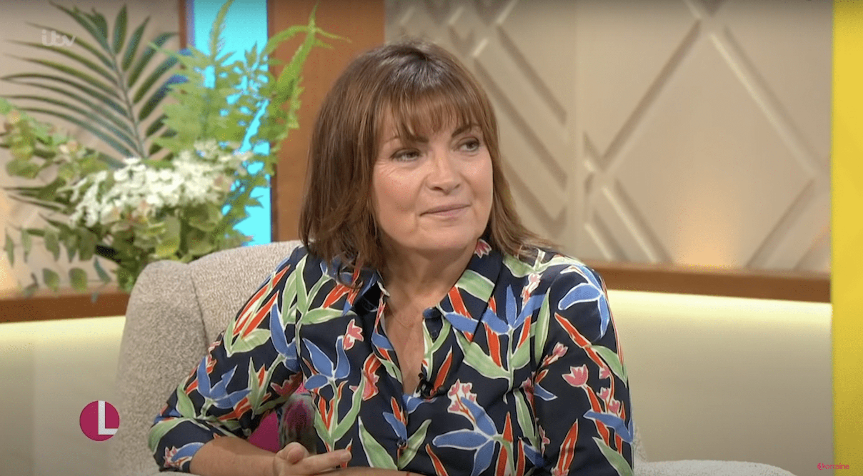 Lorraine Kelly wearing a floral dress sat down on her show 