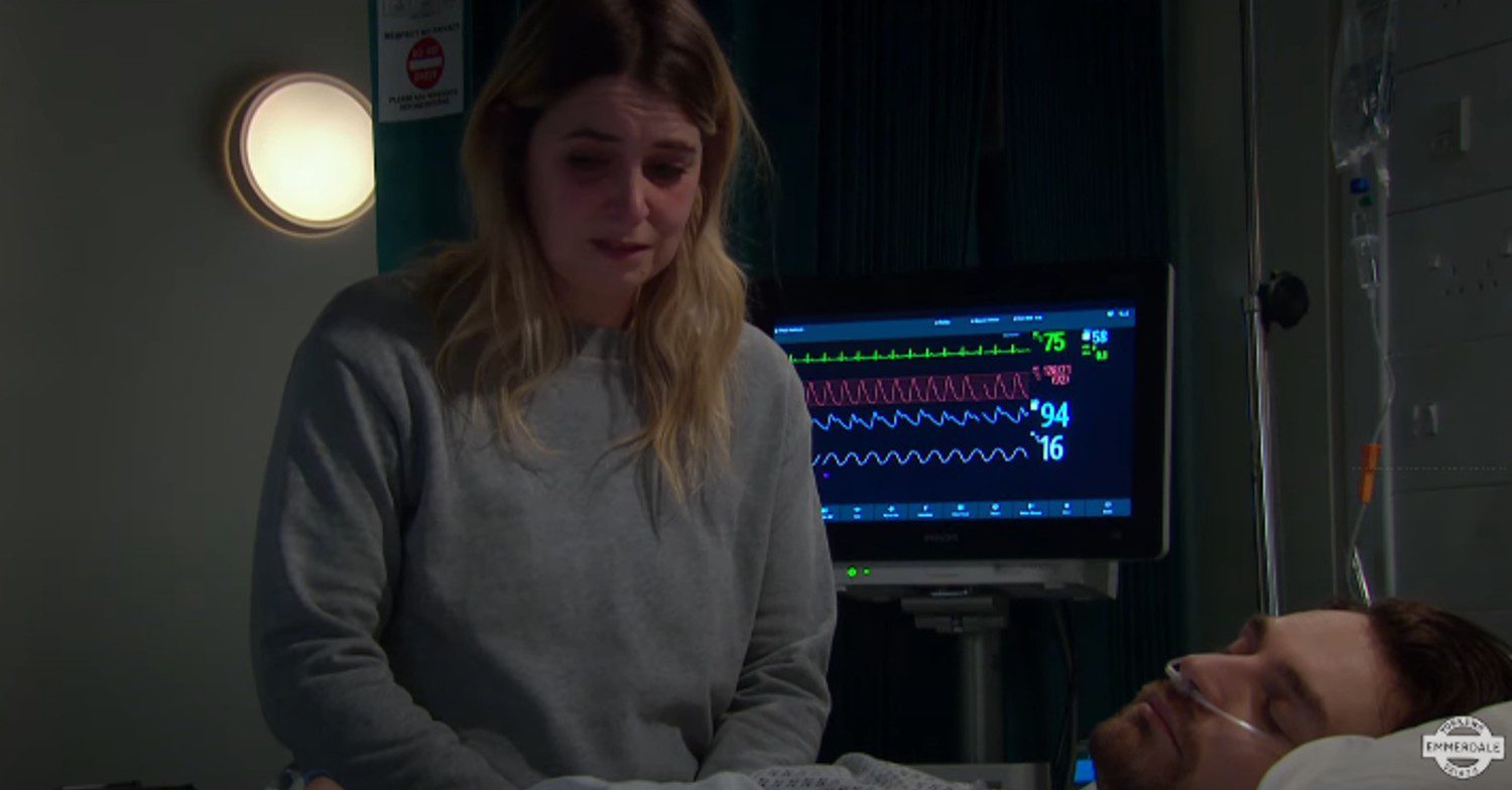 Charity stands over Mack, lying unconscious in Emmerdale