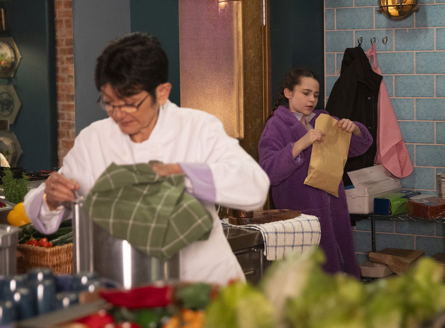 Coronation Street's Eliza is looking inside of an envelope as Yasmeen is distracted
