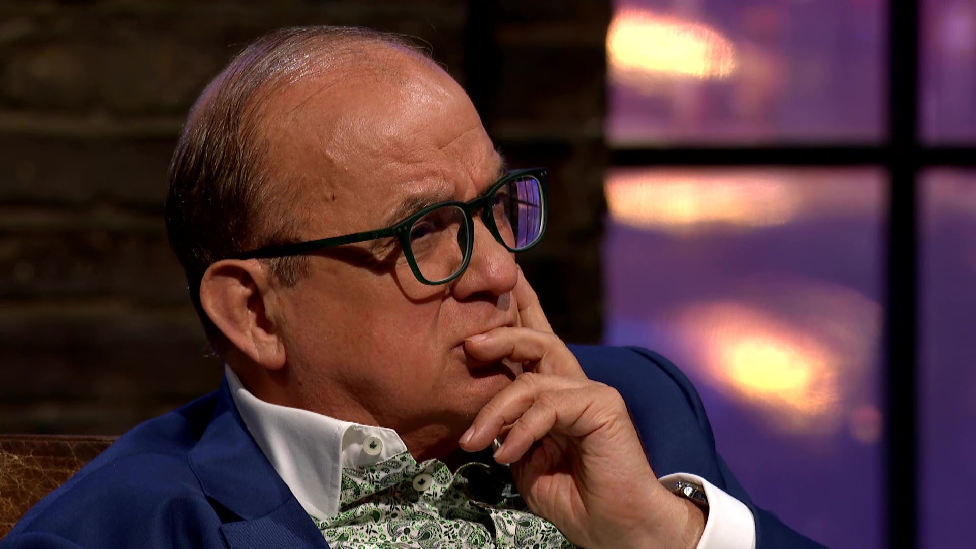 Touker Suleyman with face in hand and a thoughtful expression on Dragons' Den