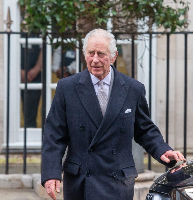 King Charles wearing a navy coat leaving hospital