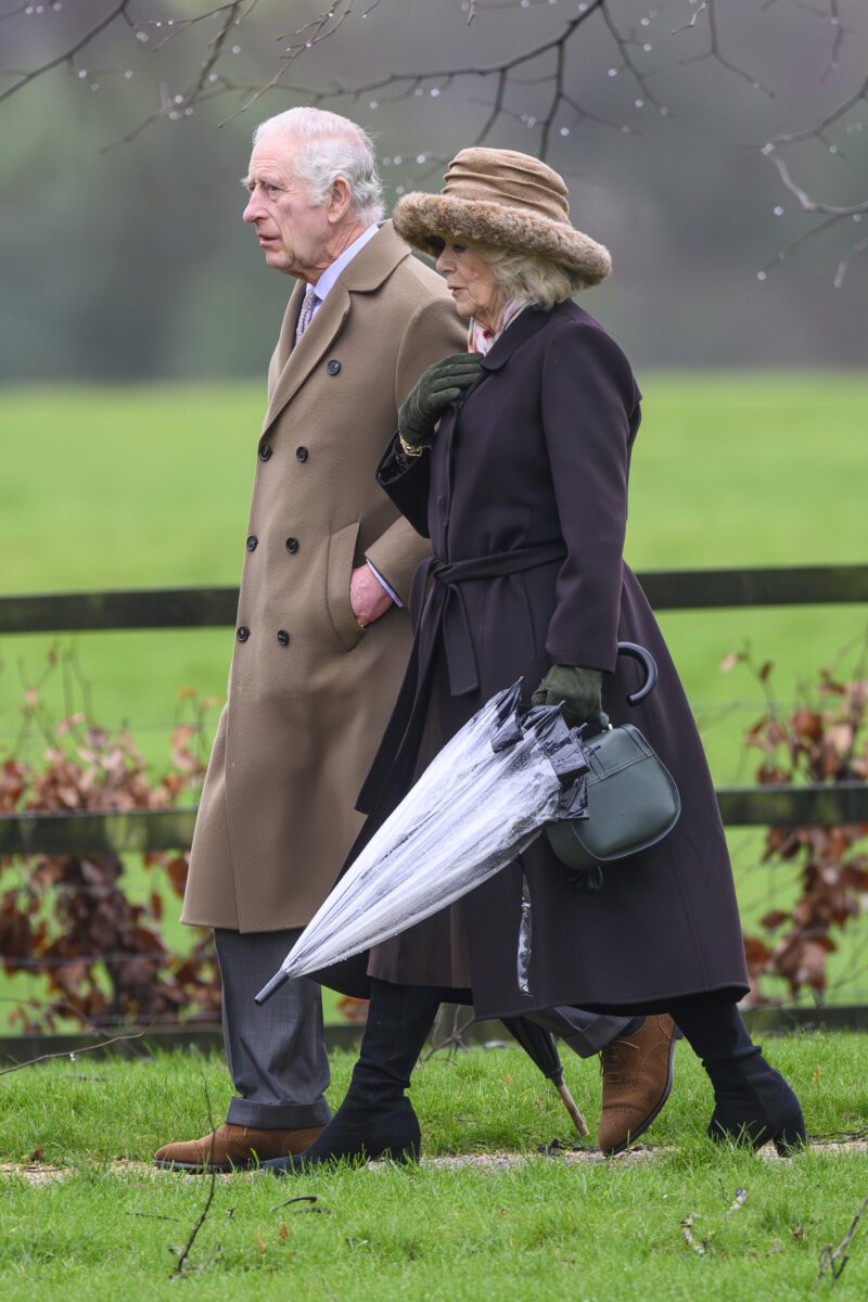 King Charles walking in the rain with Camilla