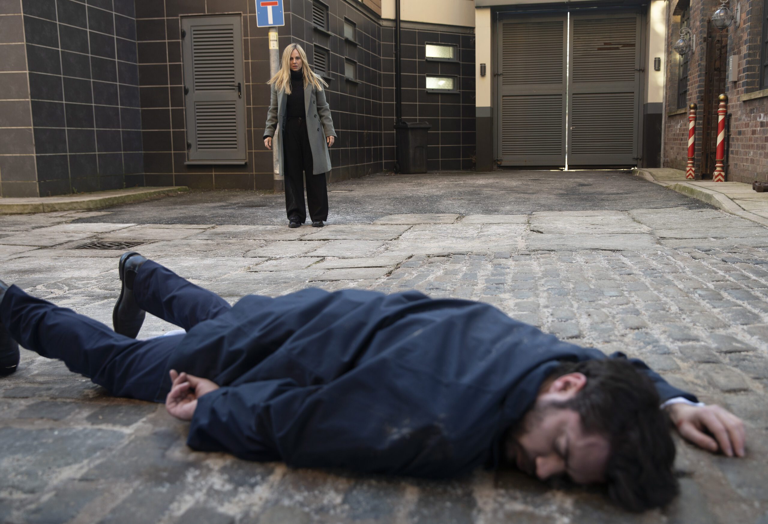 Sarah looks at lifeless Adam on the cobbles in Corrie