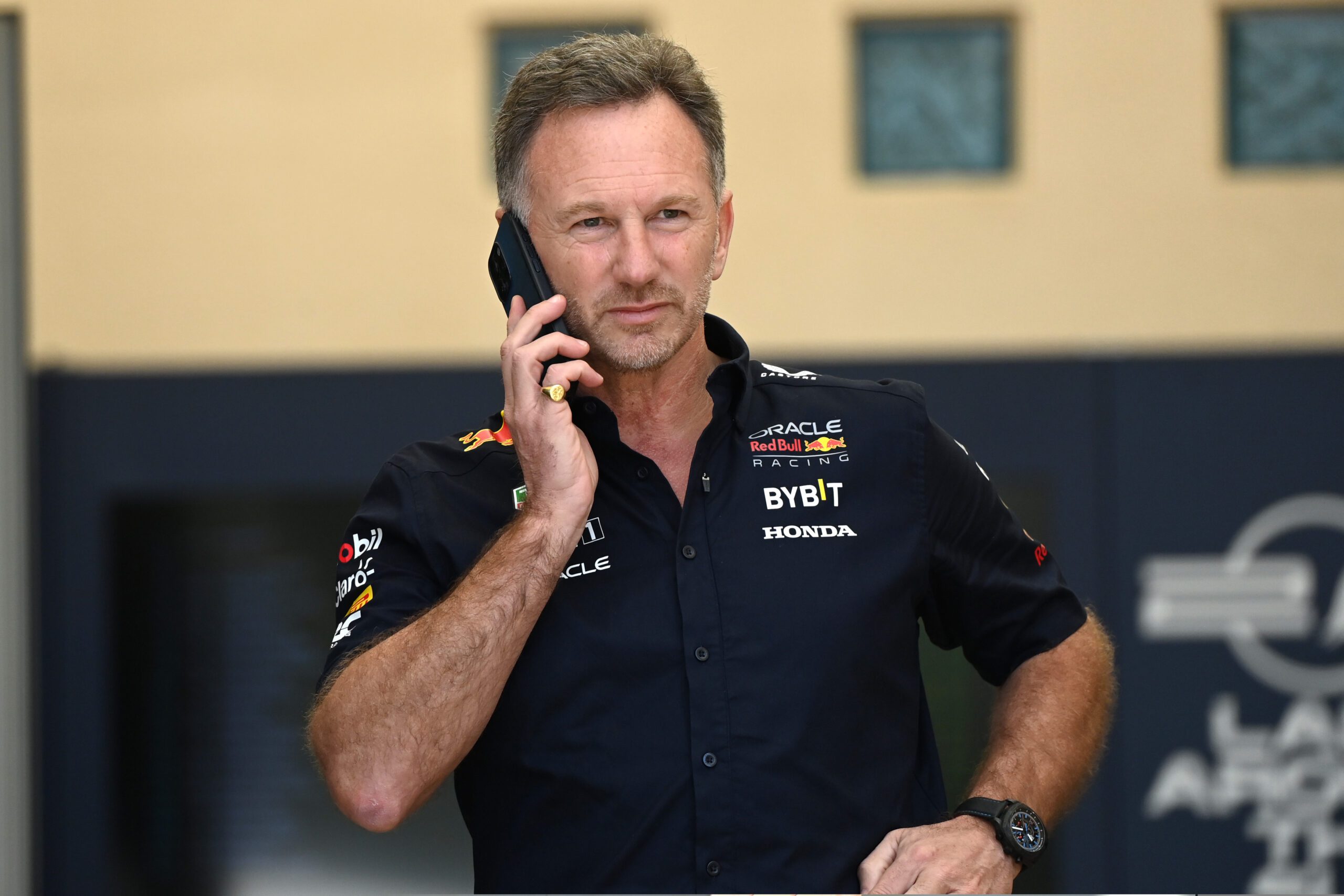 Christian Horner on his phone wearing a Red Bull team shirt