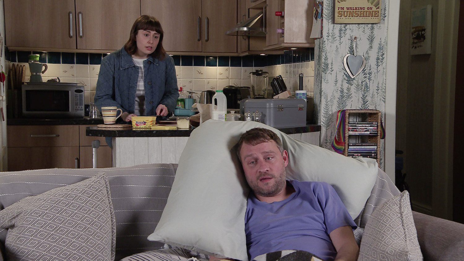 Coronation Street: Paul lies on the sofa propped up by a pillow as his PA makes a sandwich