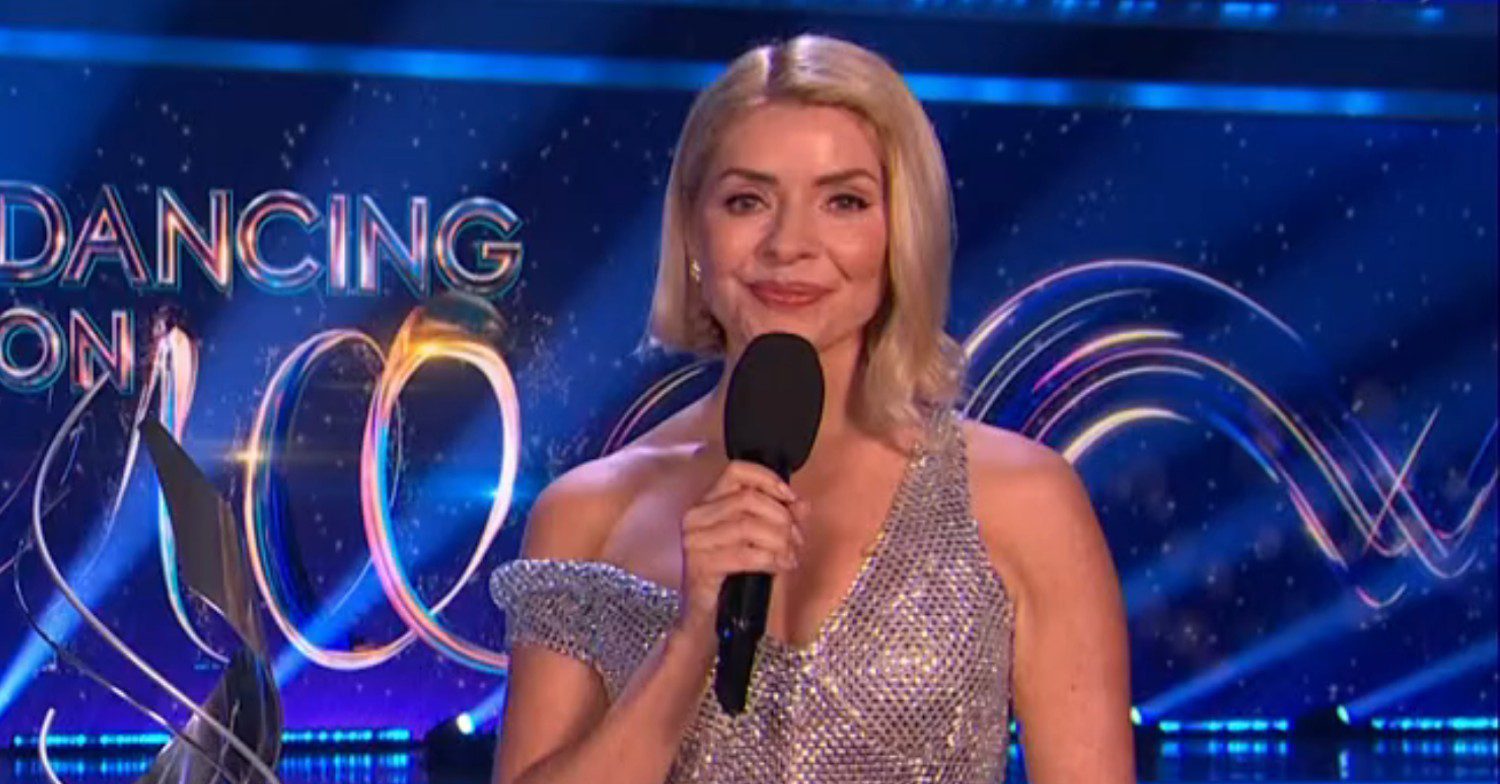 Holly Willoughby holding a microphone wearing a sequin dress