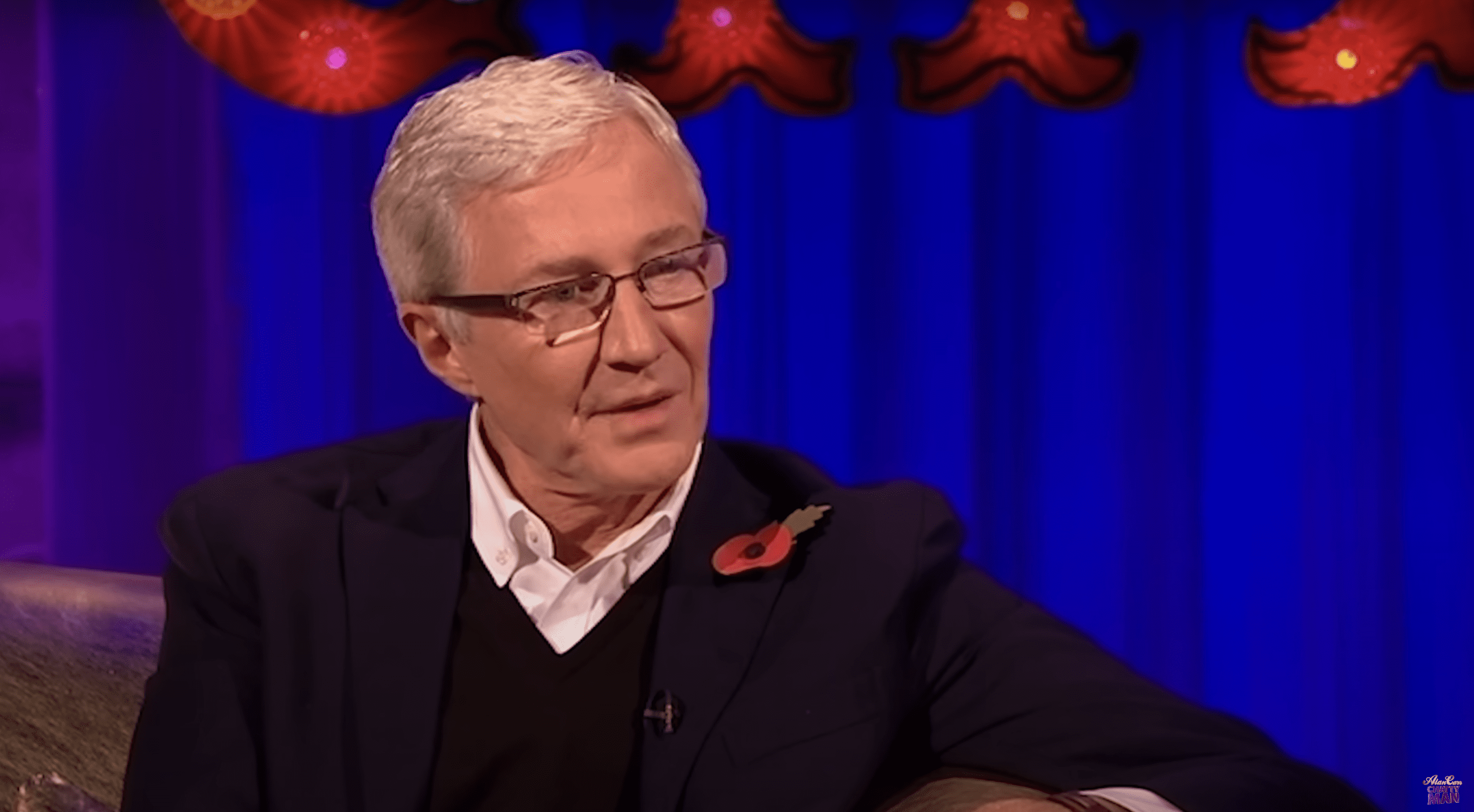 Paul O'grady smiling sat on the sofa of Alan Carr Chatty Man