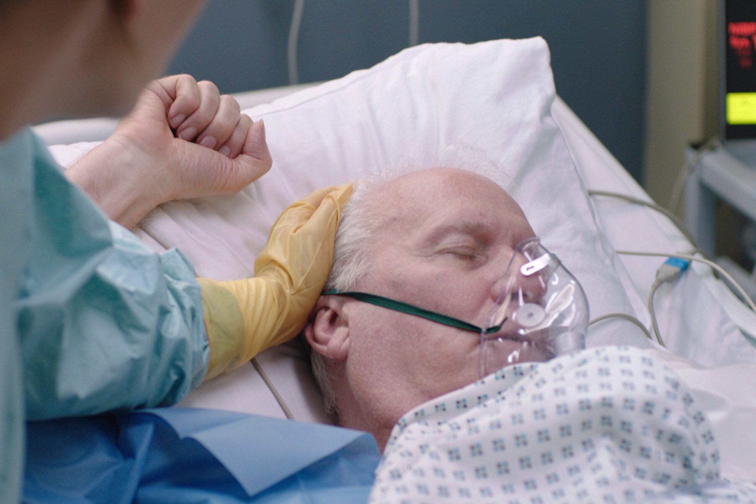 Charlie in Casualty lies in a hospital bed fighting for his life