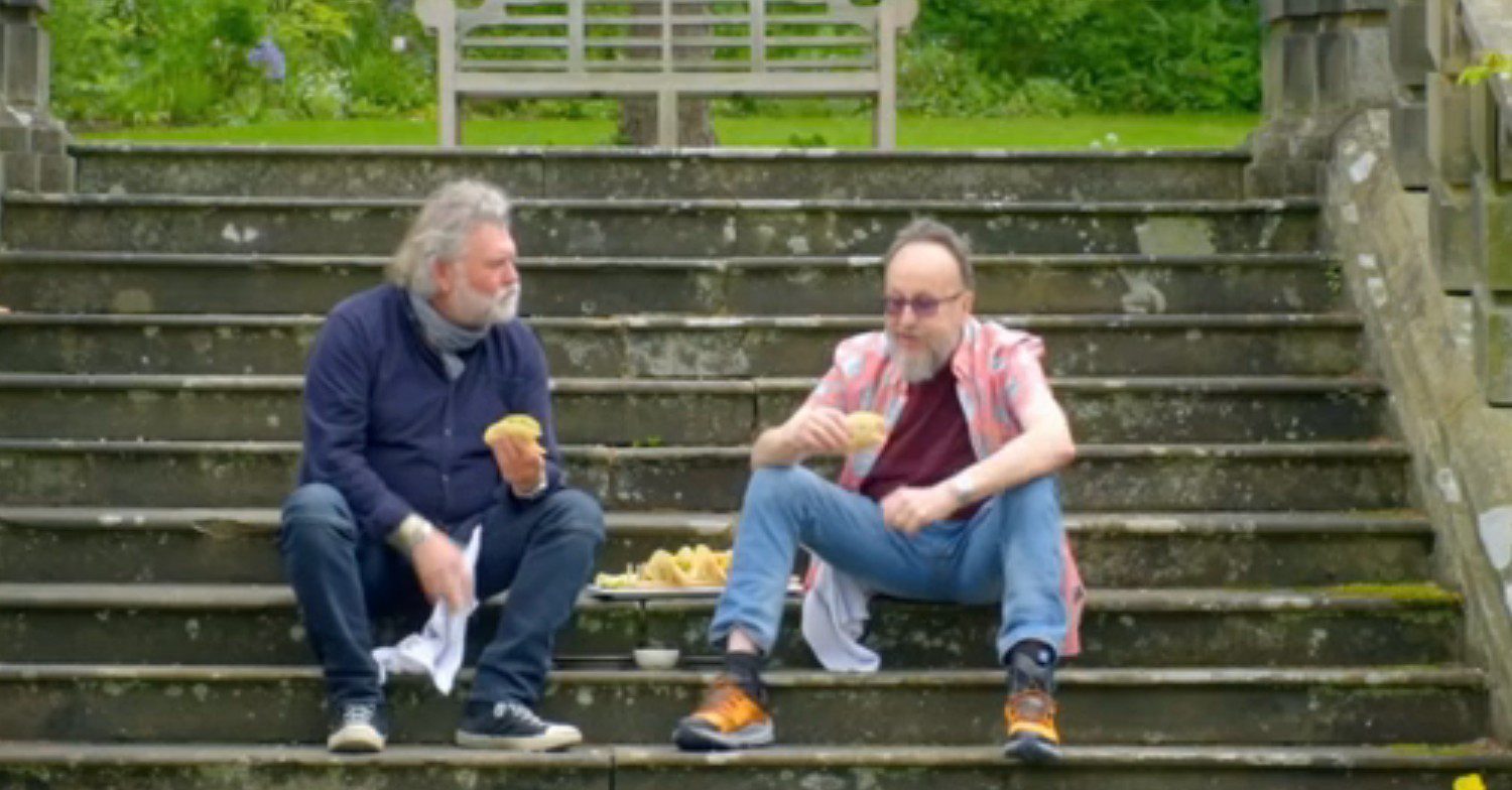 Si King and Dave Myers sitting on some steps eating 