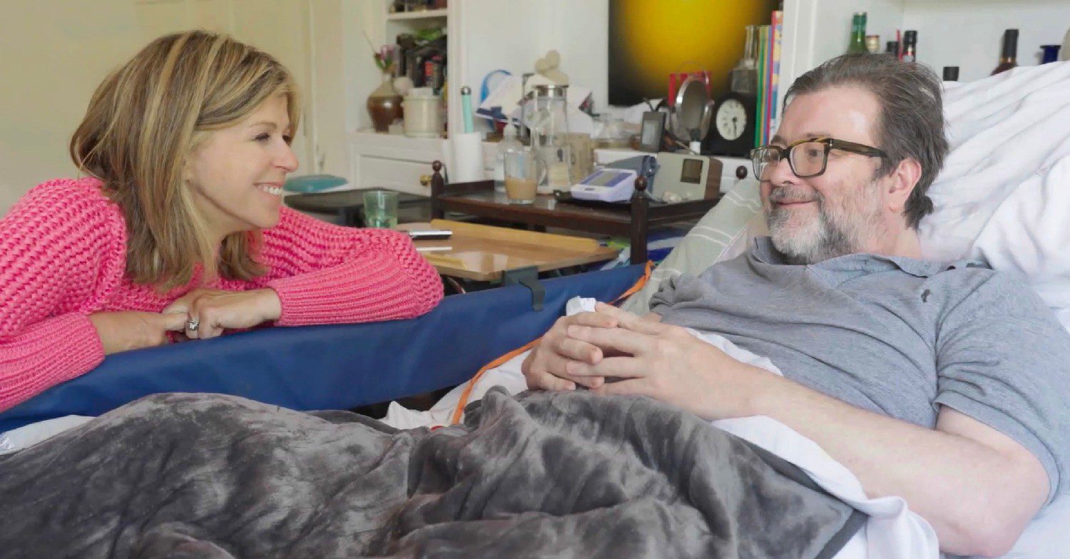 Kate Garraway looking at Derek Draper in bed