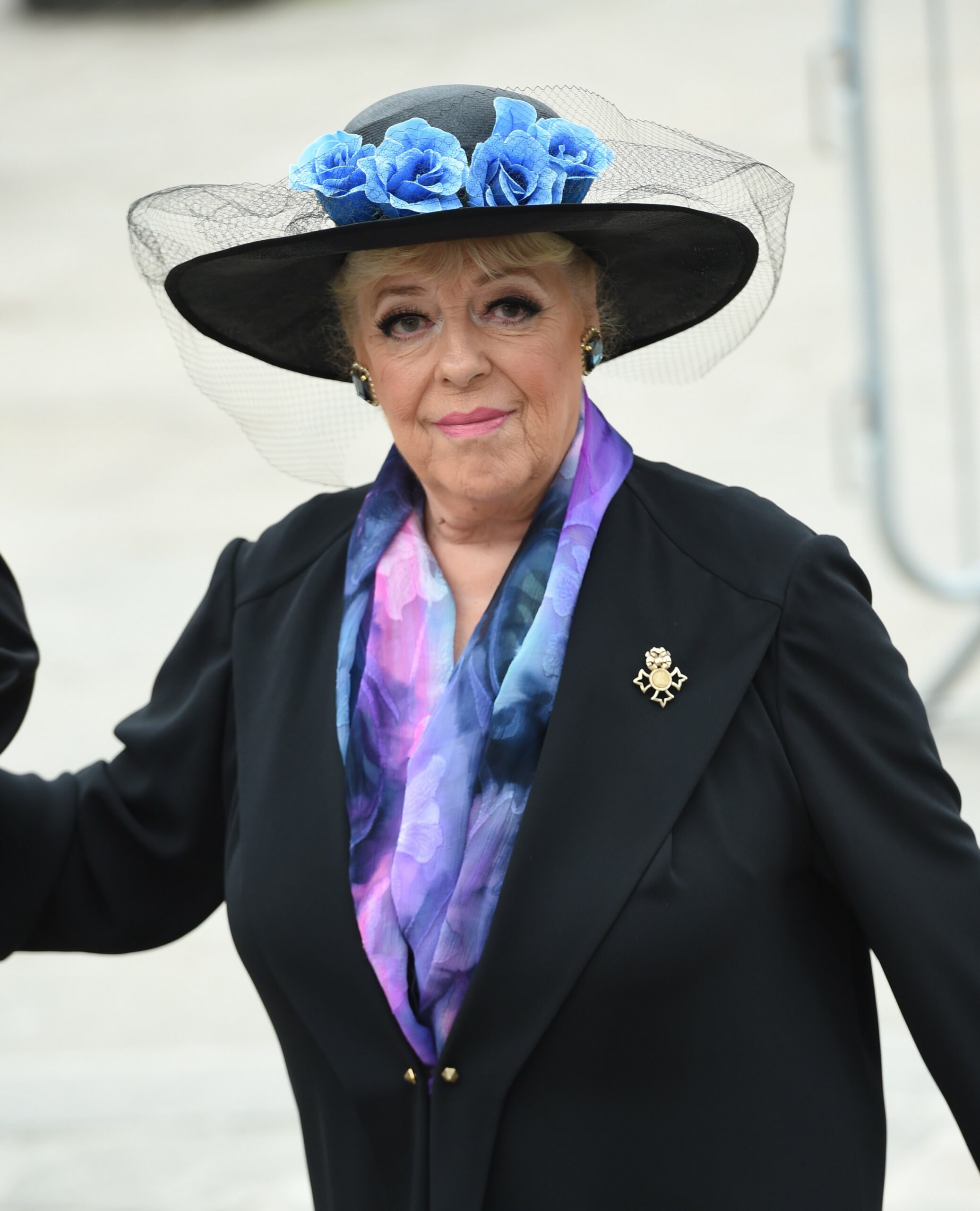 Julie Goodyear smiling in black blazer and hat