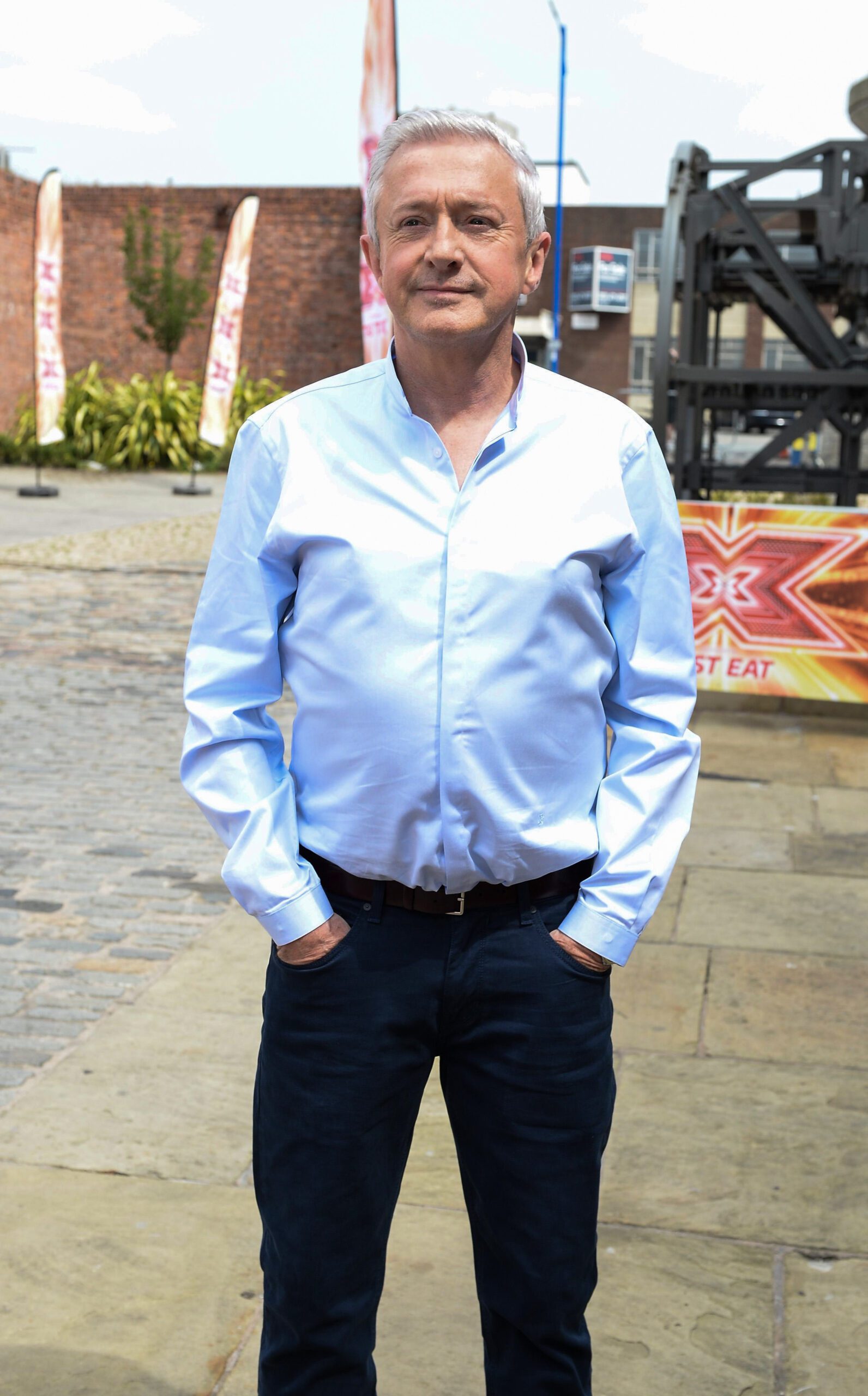 Louis Walsh hands in pockets blue shirt