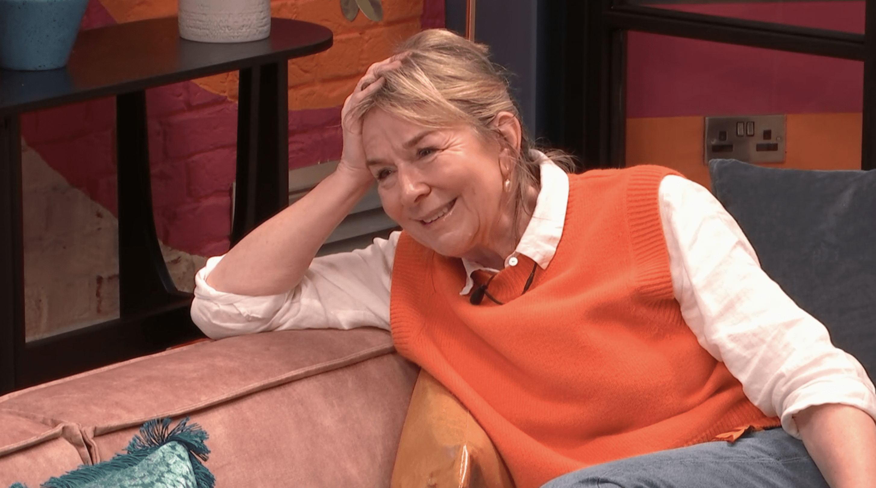 Fern Britton smiling wearing an orange vest whilst talking to Nikita Kuzmin on Celebrity Big Brother