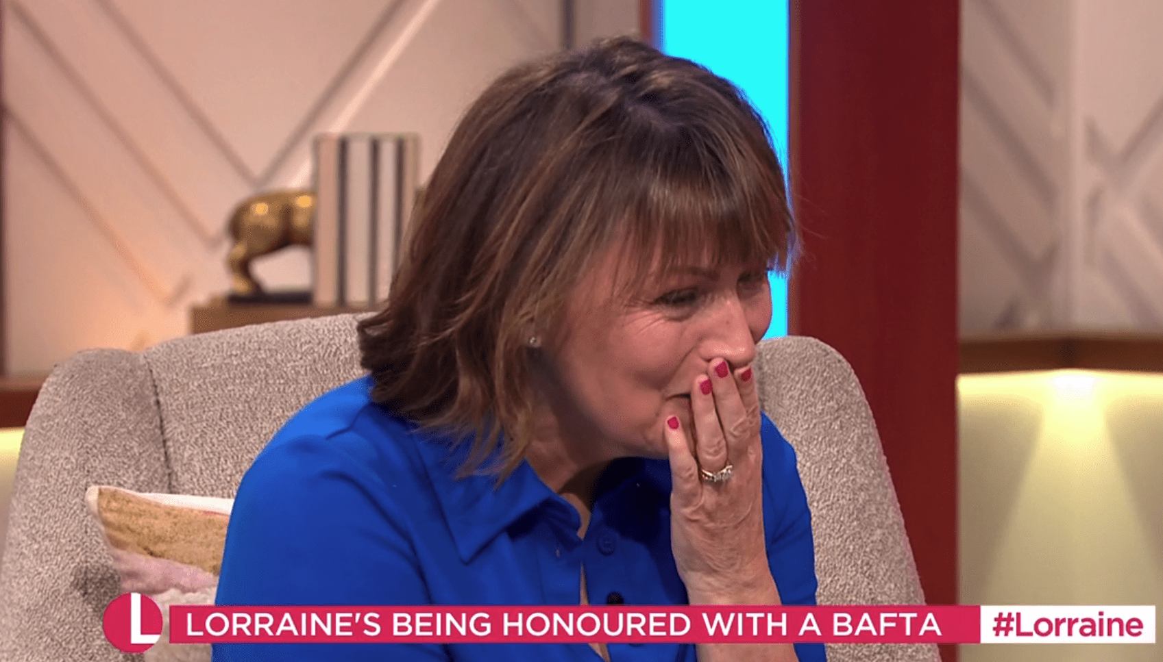 Lorraine Kelly with her hand over her mouth