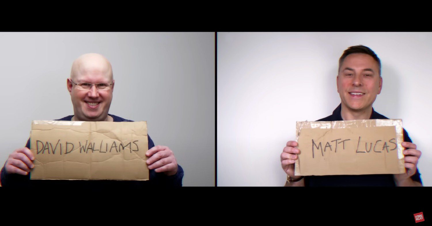Matt Lucas and David Walliams holding up signs 