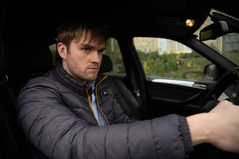 Tom looking angry in his car on Emmerdale