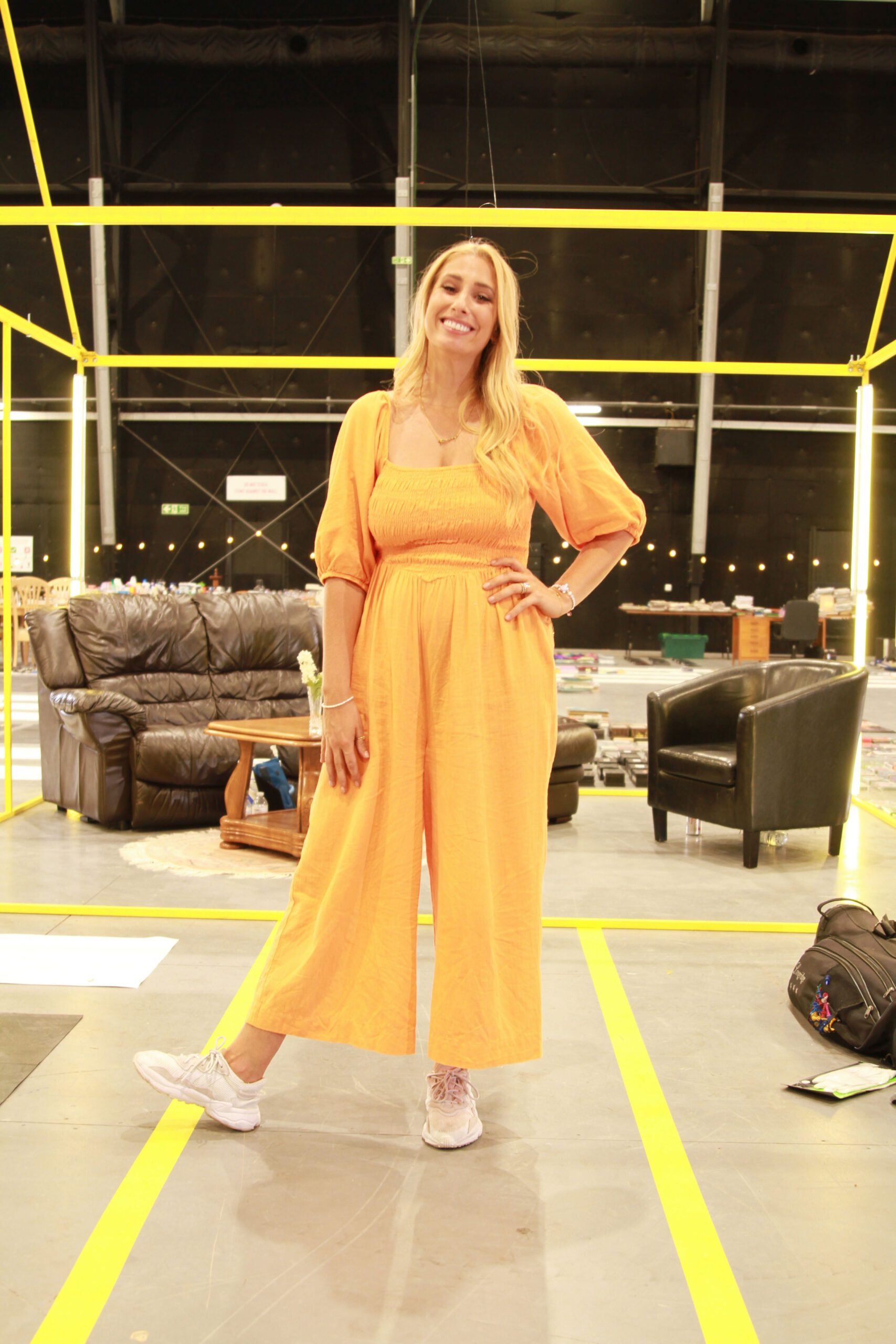 Stacey Solomon smiling and wearing an orange jumpsuit on Sort Your Life Out
