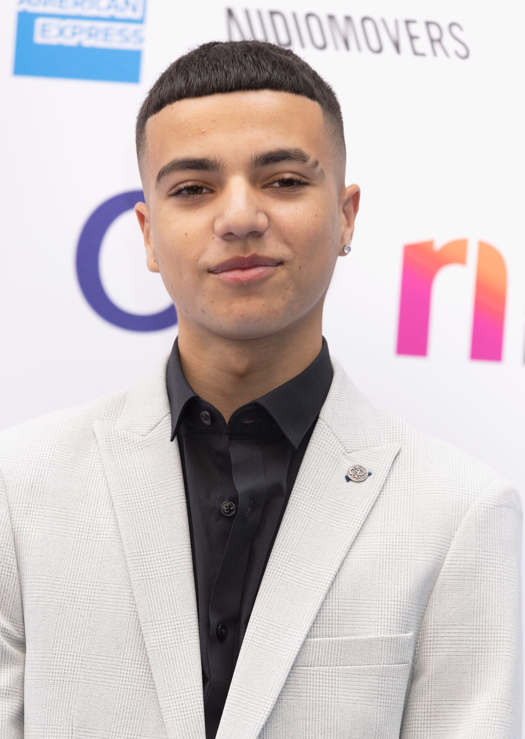Junior Andre smiling wearing white suit
