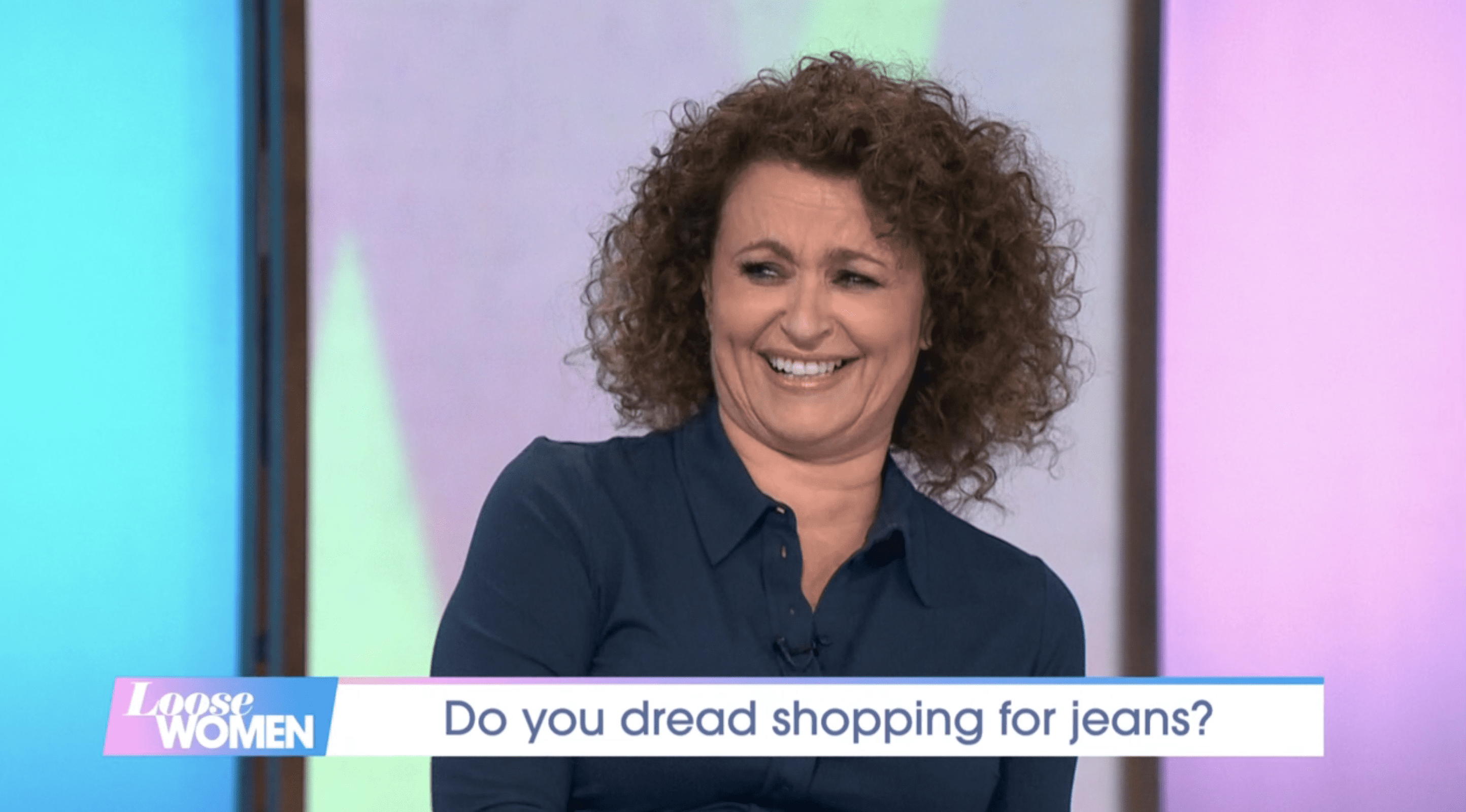 Nadia Sawalha laughing on set of Loose Women wearing blue shirt