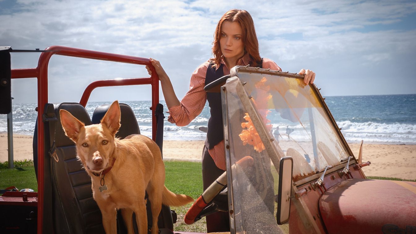 Teaser image from Return to Paradise, showing new lead Anna Samson, a dog, and an automobile on the Australian coast