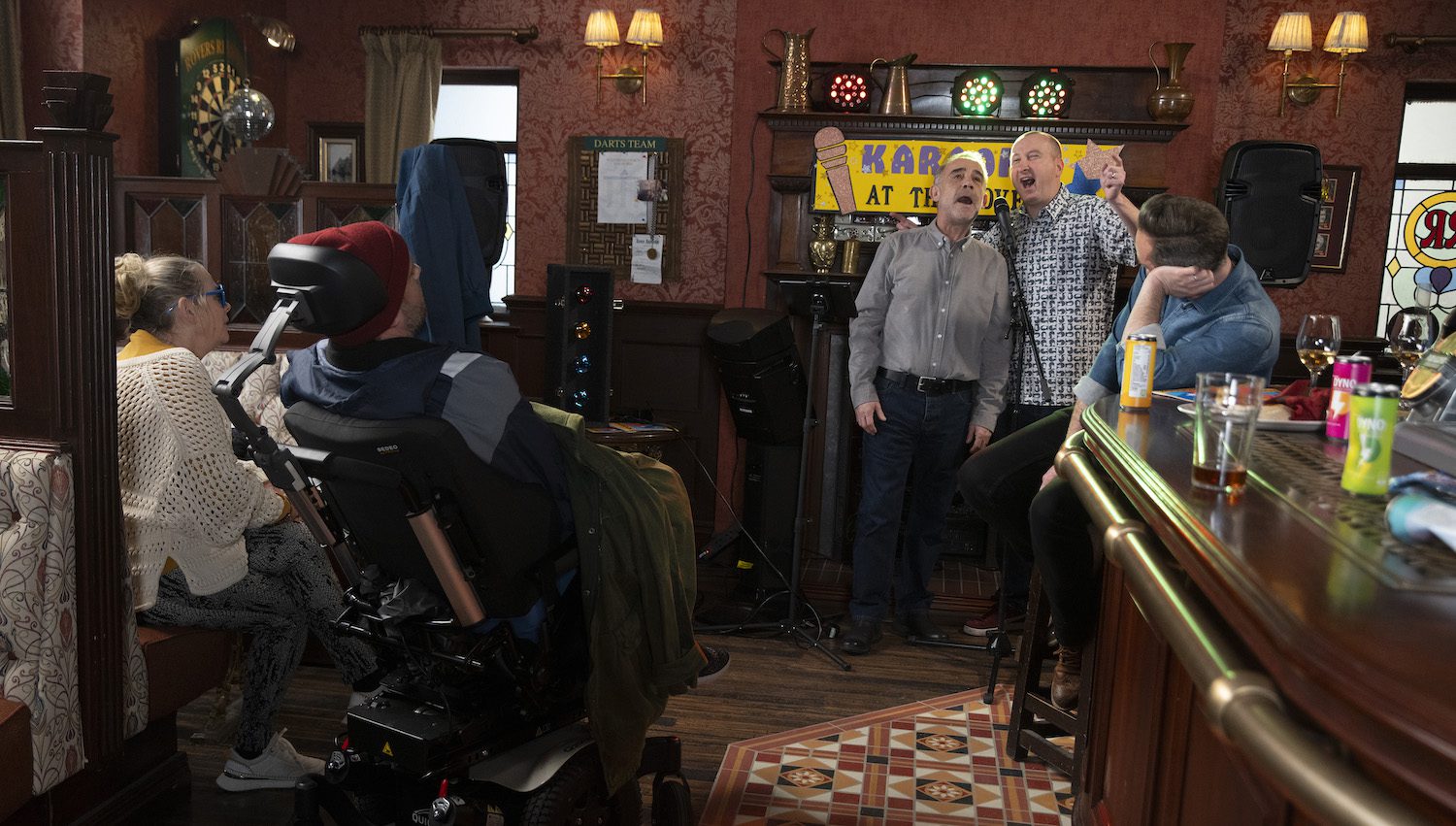 Kevin and Kirk sing enthusiastically at the karaokethon in the Rovers in Corrie