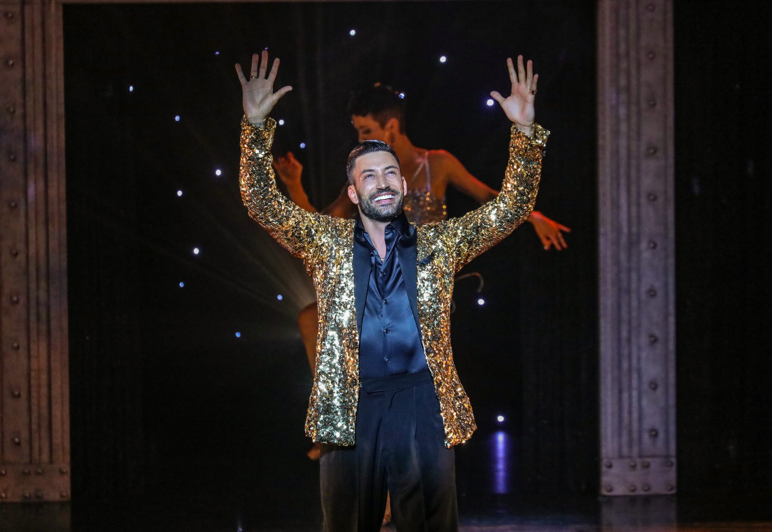 Giovanni Pernice sporting a gold glittery suit on stage