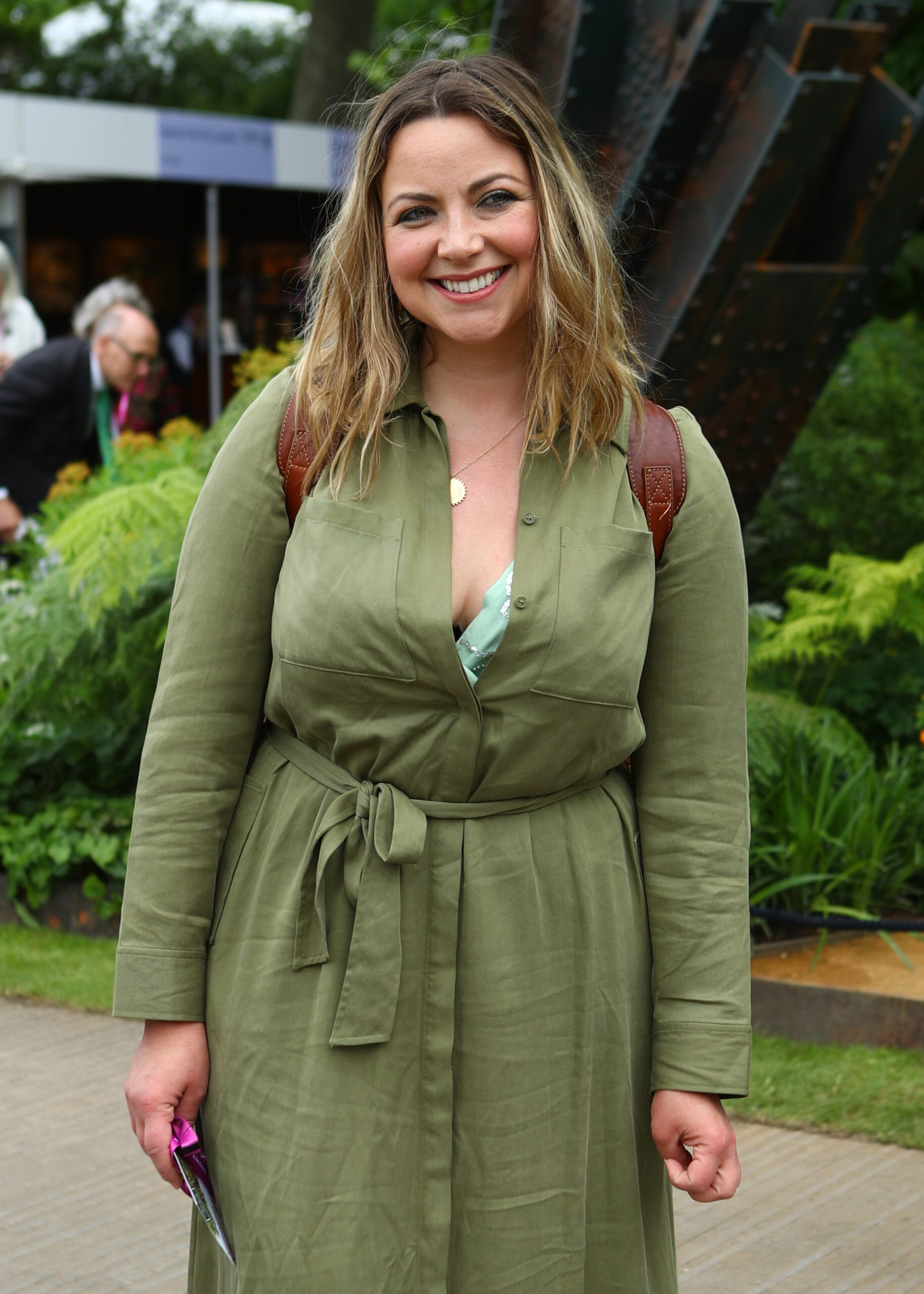 Charlotte Church smiling wearing green jumpsuit and rucksack