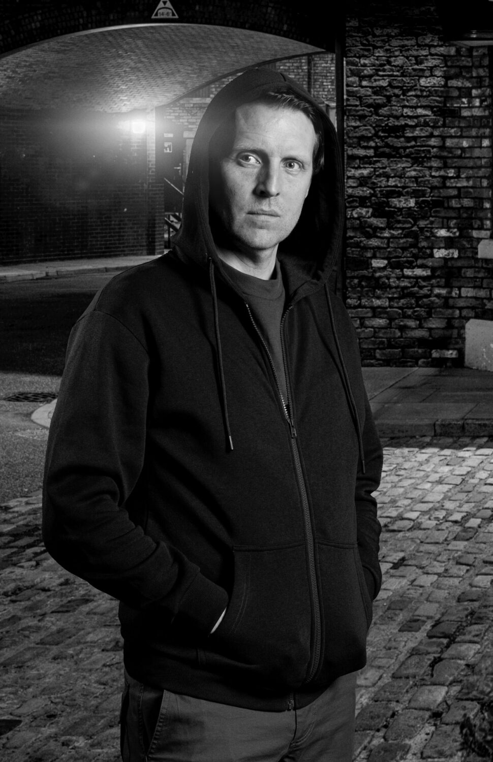 Promo shot of Nathan in Coronation Street in black and white - shows him with his hoodie up