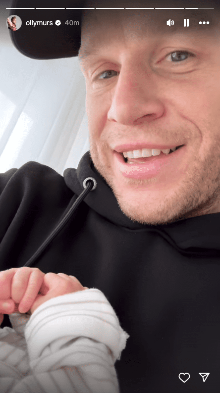Olly Murs holding his baby