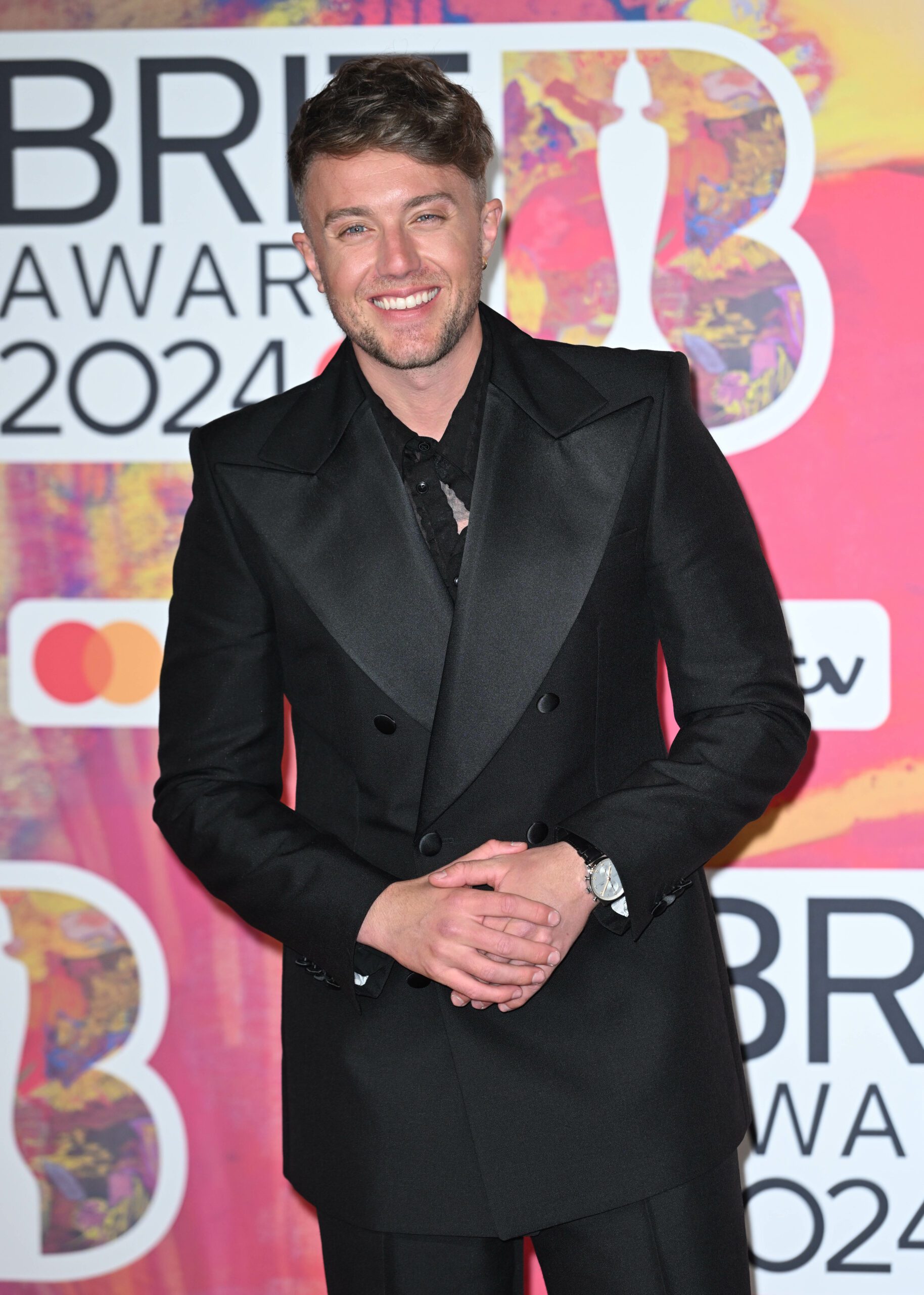 Roman Kemp smiling in a suit at the BRITS