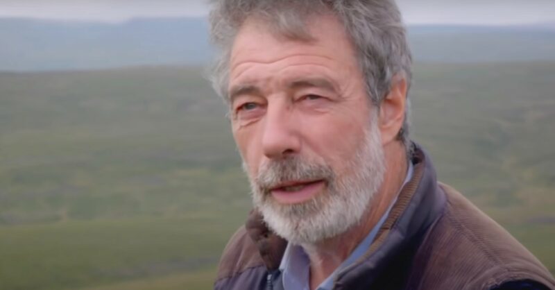 Clive Owen speaking to camera on the farm