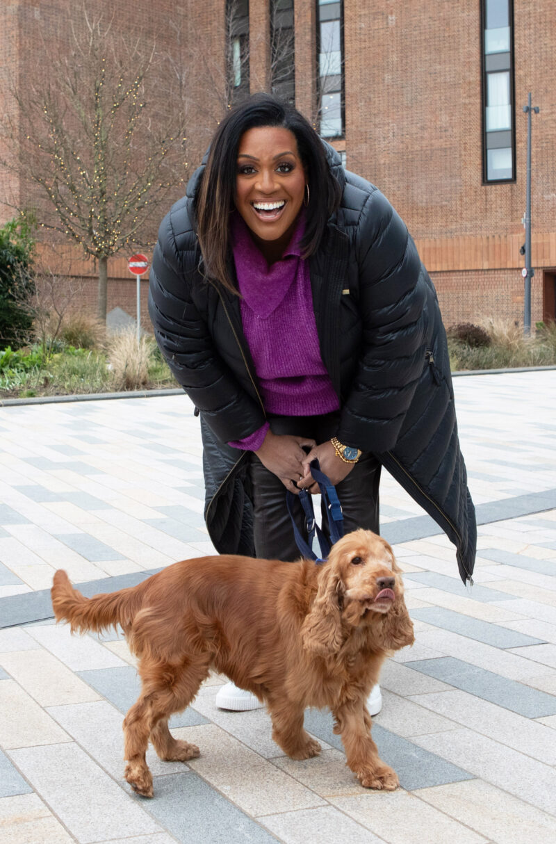 Alison smiles with a dog on a lead