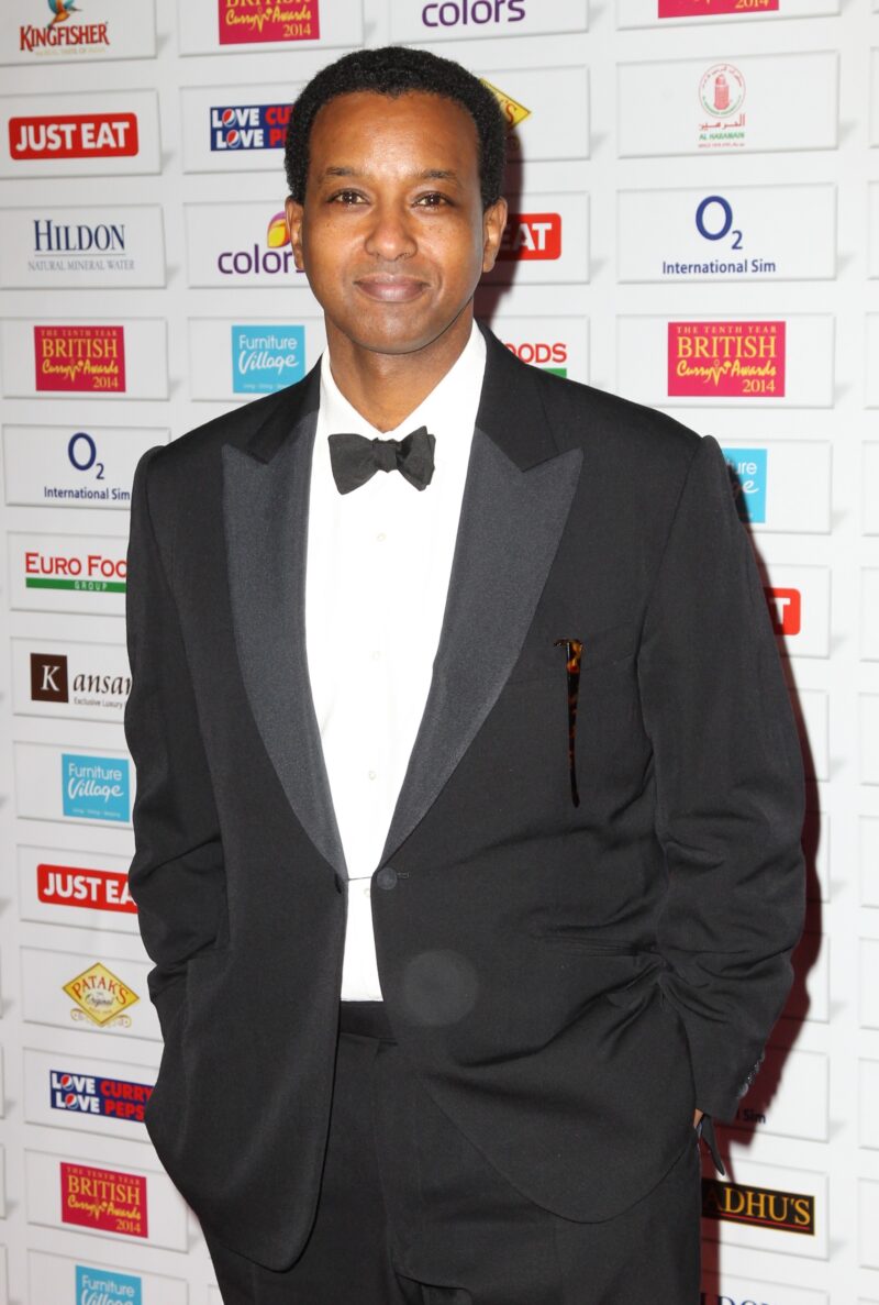 Rageh Omaar in a suit and bow tie smiling