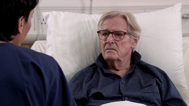 Ken Barlow in Corrie in a hospital bed looking unhappy