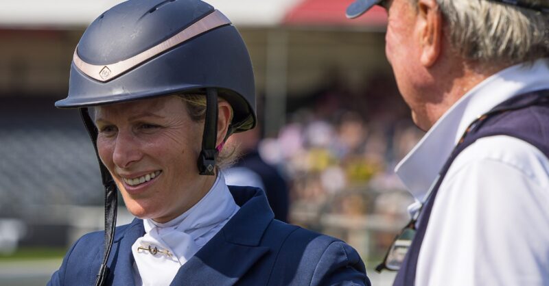 Zara Phillips wearing a horse riding hat alongside her father Mark Phillips