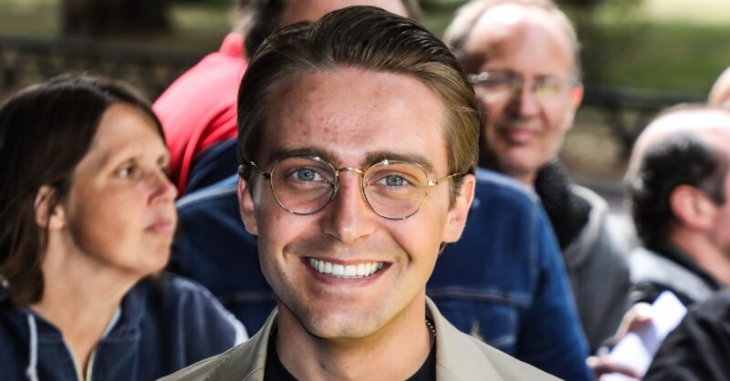 Barney Walsh smiling wearing glasses