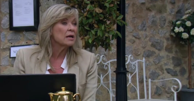 Emmerdale's Kim is sitting outside of the B&B