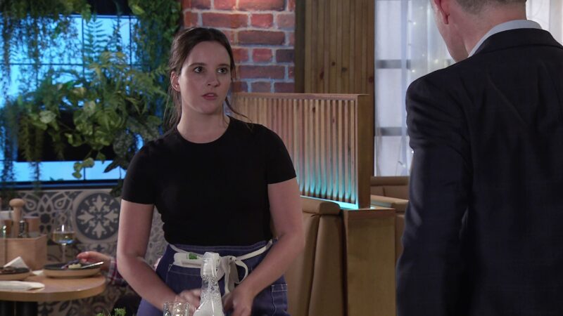 Amy looks fed up in the bistro in Coronation Street