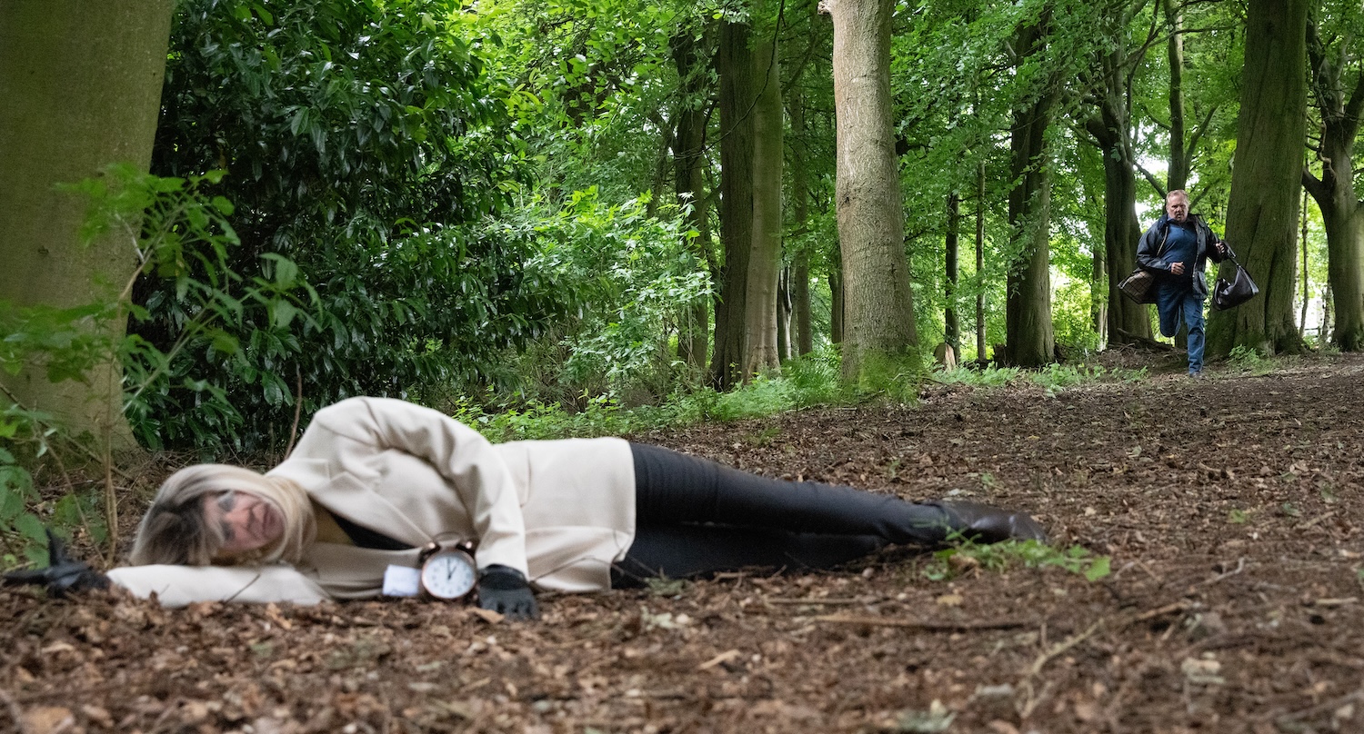 A mannequin wearing Kim's clothes lies in the woods