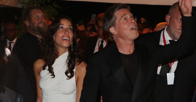 Brad Pitt and his new girlfriend Ines de Ramon smiling and waving whilst looking upwards