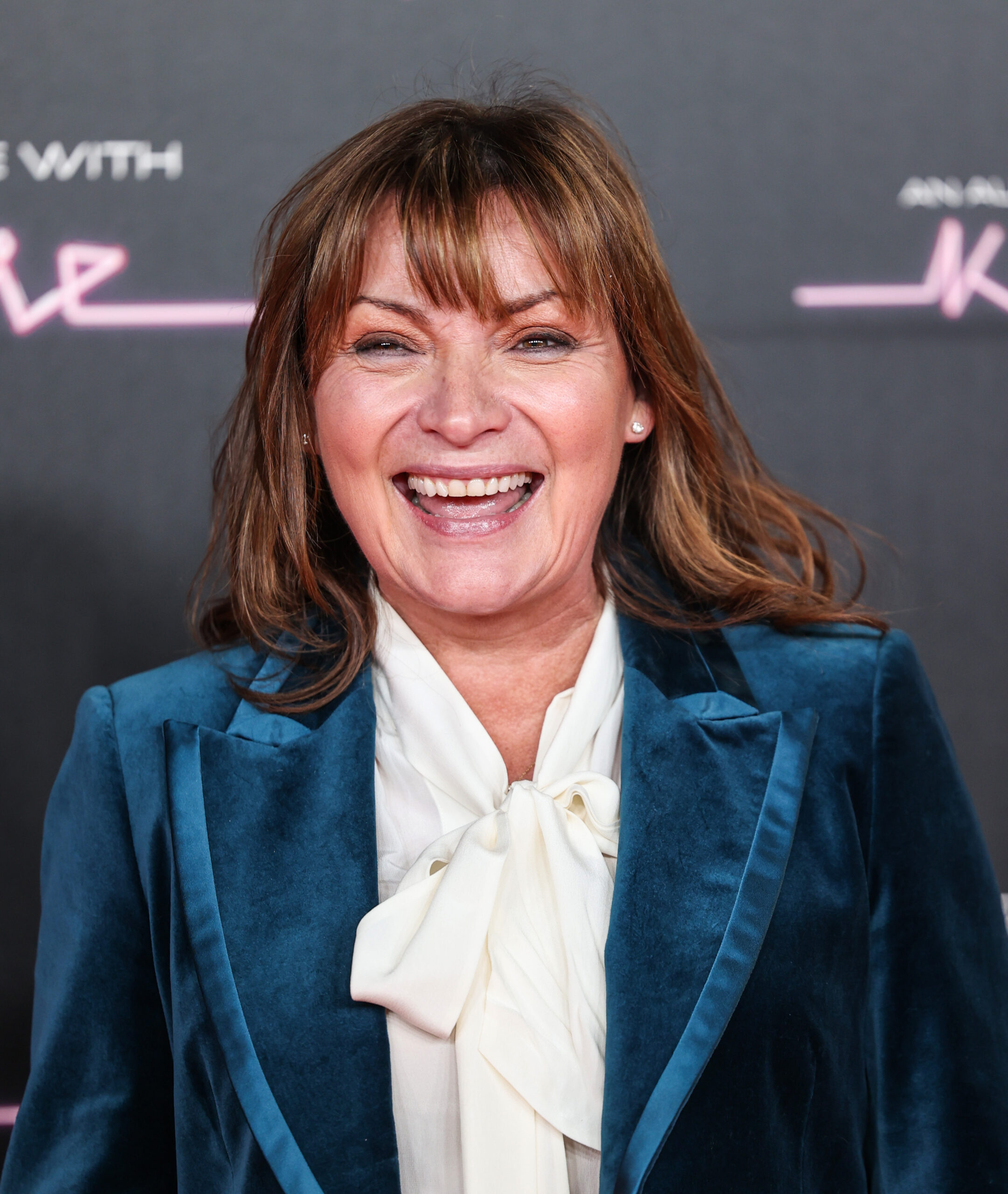Lorraine Kelly smiling in blue velvet blazer at event