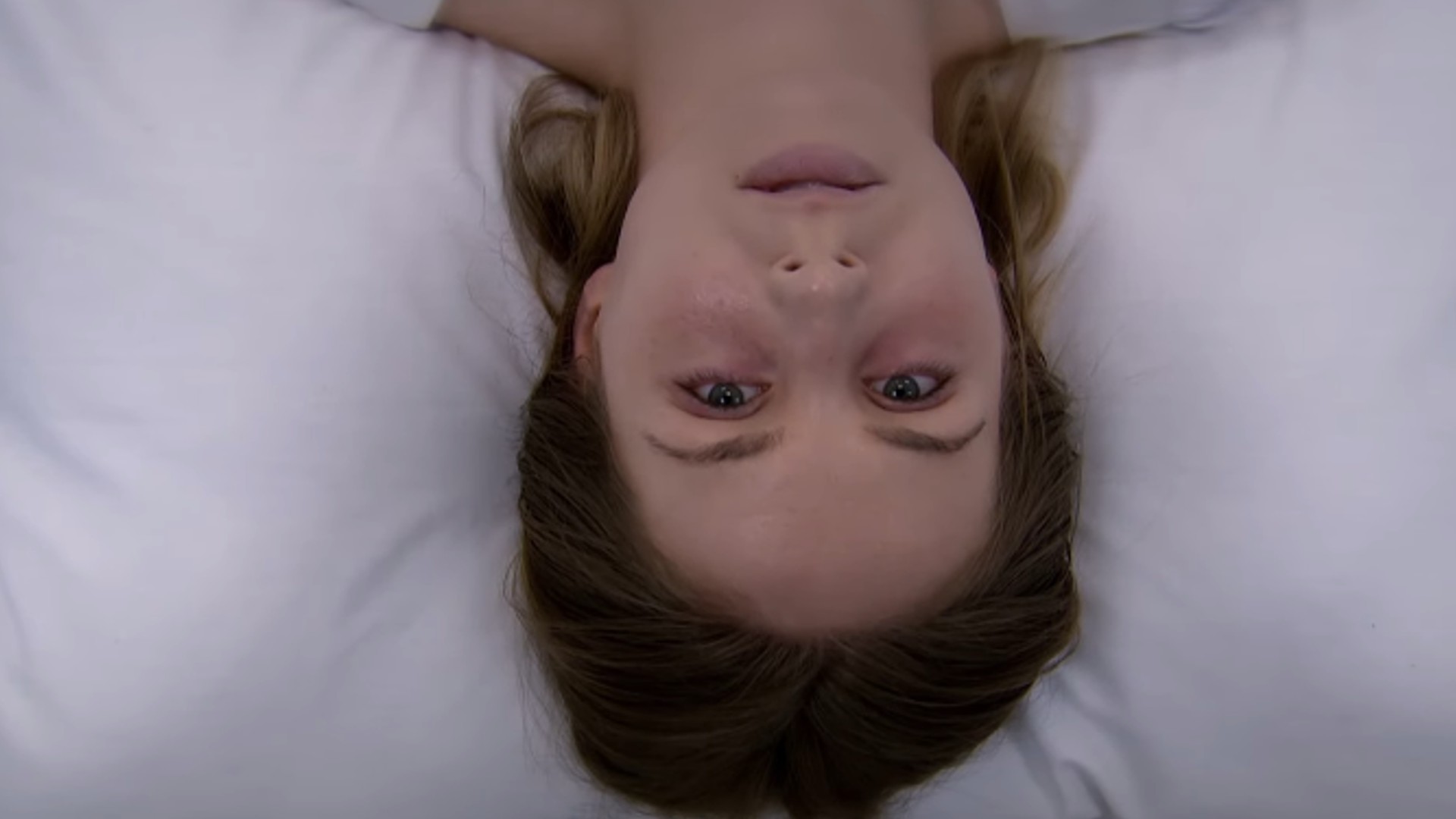 Belle looks at the camera from her bed in a psytch ward