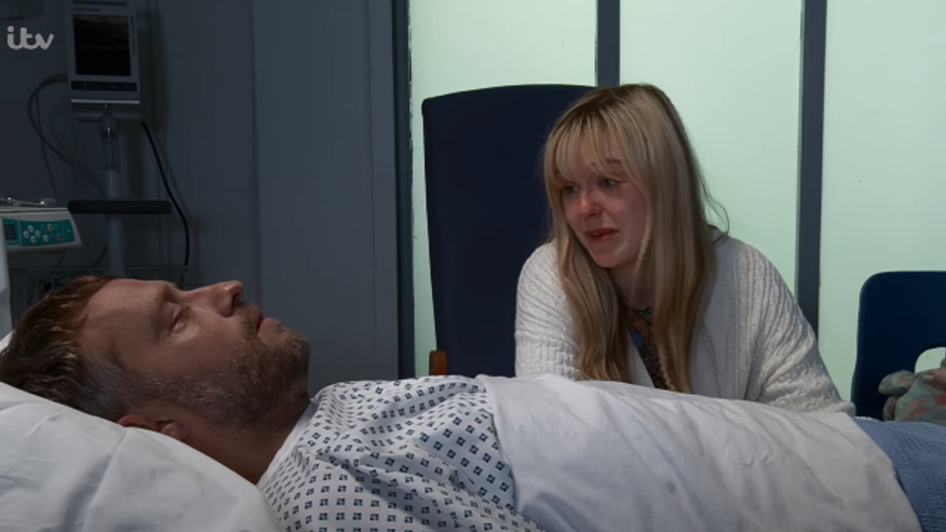 Paul lying in his hospital bed while Summer looks on crying on Coronation Street