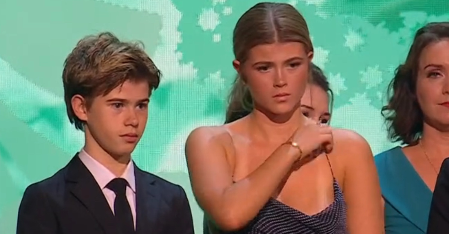 Kate Garraway's daughter Darcey touching her dress on stage beside brother Billy at the NTAs