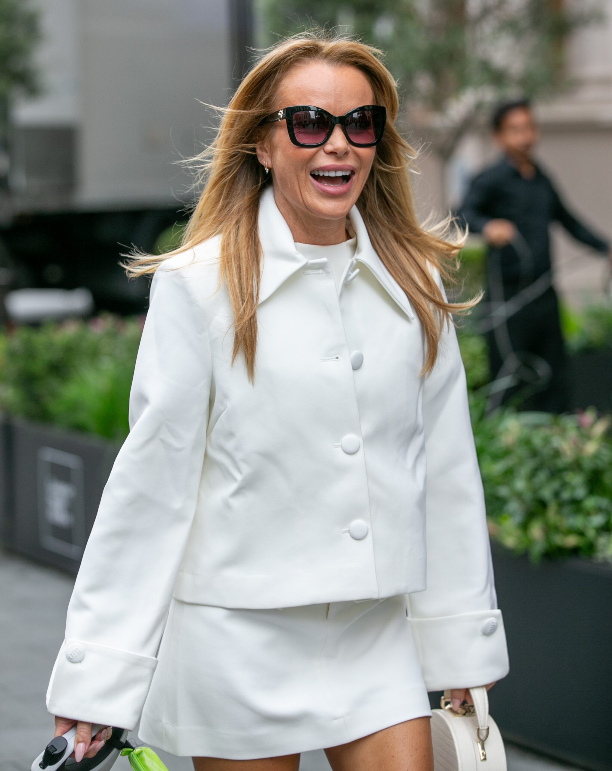 Amanda Holden smiling in white outfit outside radio studios