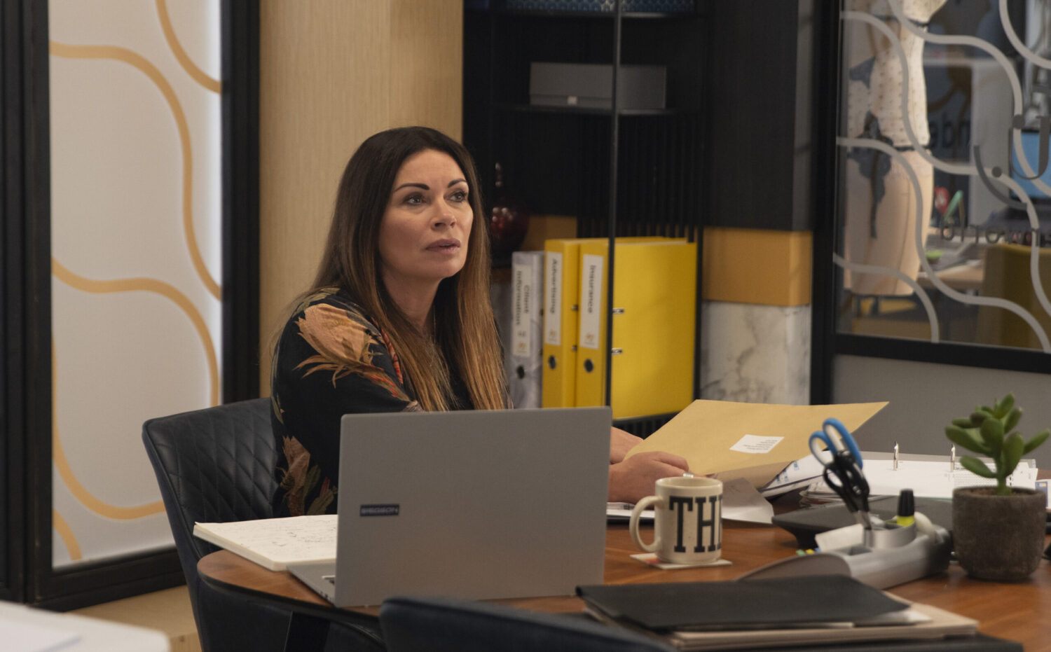 Coronation Street's Carla is holding a letter in the factory