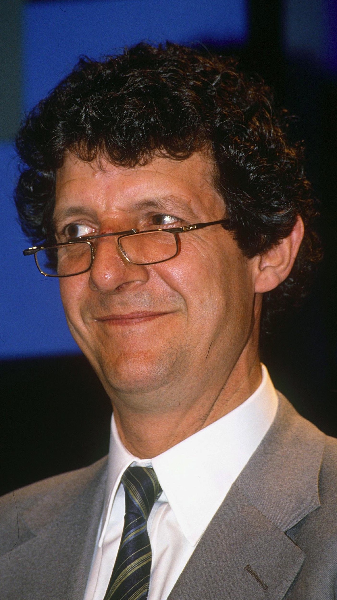 A middle-aged Chris Serle smiling and wearing glasses