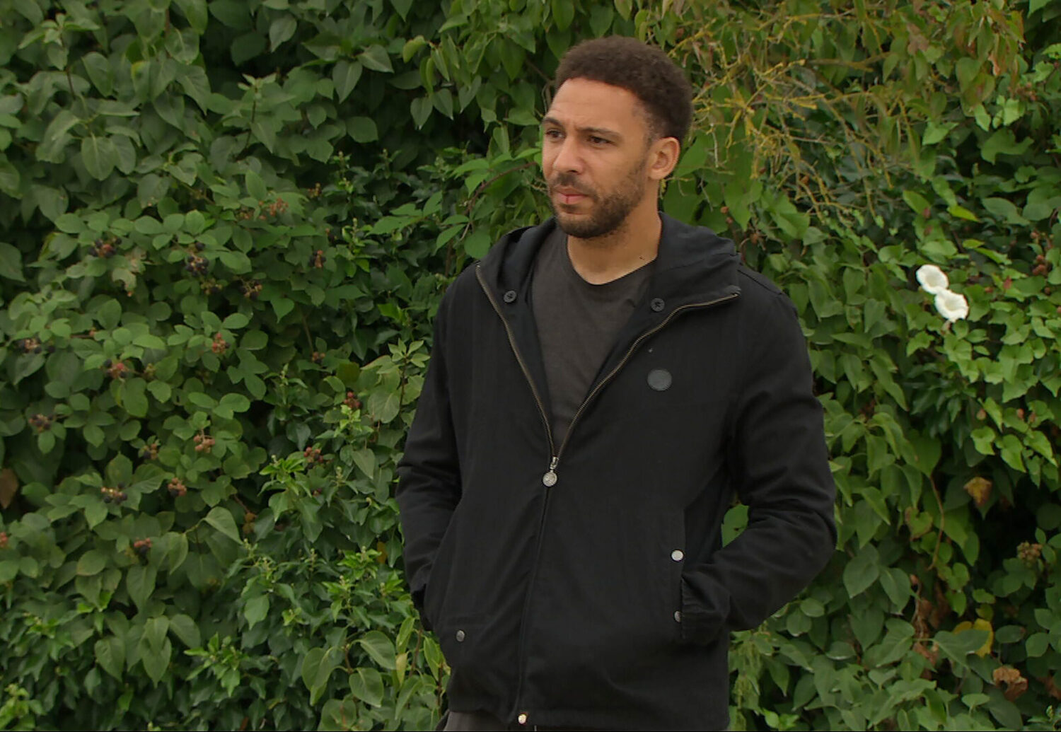 Billy standing seriously in Emmerdale